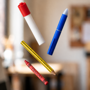 Doodle Drama red-capped marker, blue ballpoint pen with blue clip, yellow pencil, and red crayon floating in the air